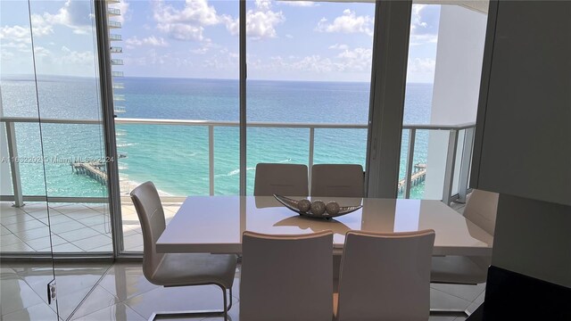 dining room featuring tile patterned floors and a water view