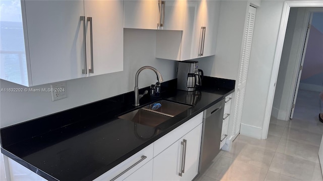 kitchen featuring dishwasher, white cabinetry, sink, and light tile patterned floors