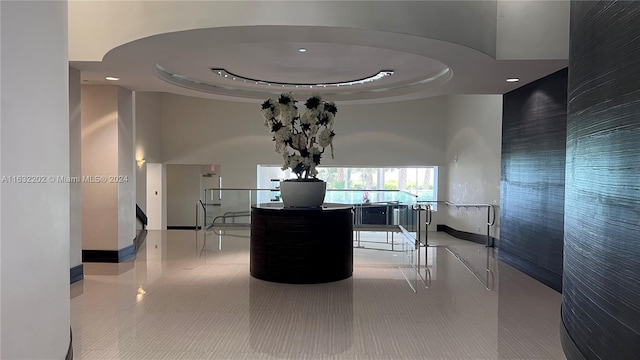 hall with a towering ceiling and a tray ceiling