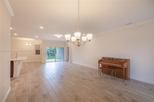 unfurnished room with a chandelier, sink, ornamental molding, and light wood-type flooring