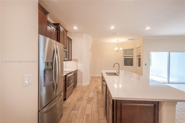 kitchen with appliances with stainless steel finishes, a kitchen island with sink, ornamental molding, and sink