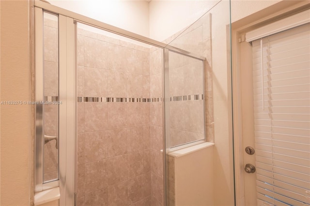 bathroom featuring a shower with door