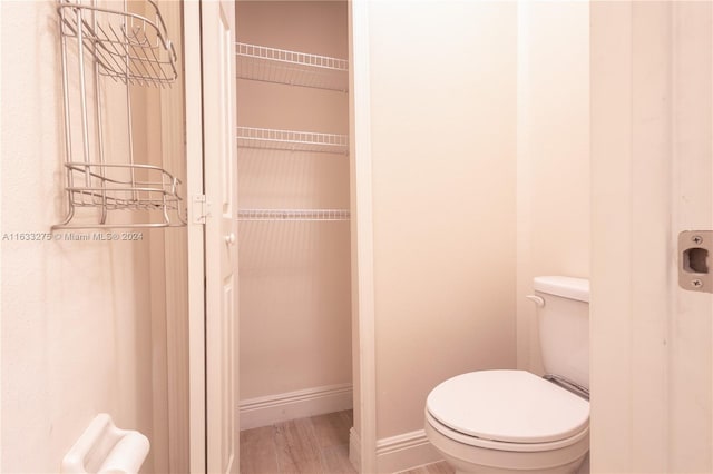 bathroom featuring hardwood / wood-style flooring and toilet