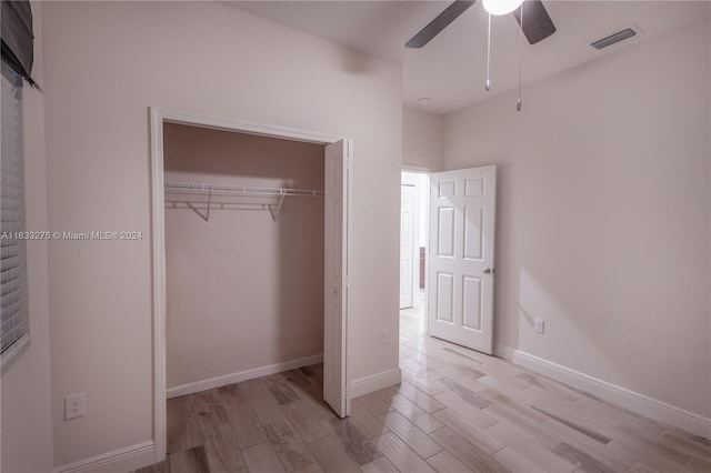 unfurnished bedroom with ceiling fan, a closet, and light wood-type flooring