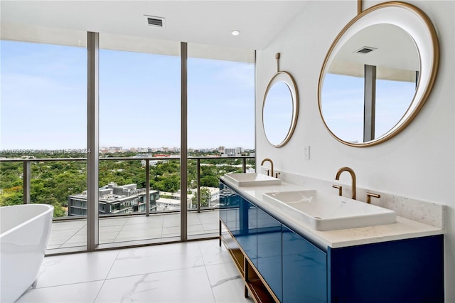 bathroom featuring expansive windows, vanity, and a tub