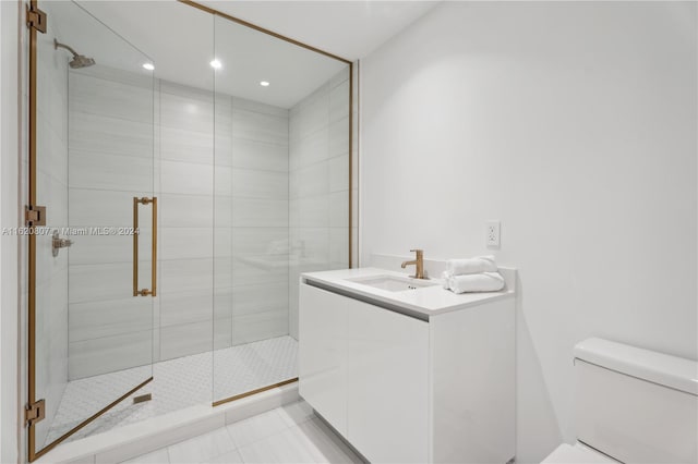 bathroom featuring toilet, tile patterned floors, vanity, and a shower with door