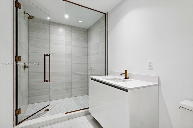 bathroom featuring toilet, vanity, tile patterned floors, and a shower with shower door