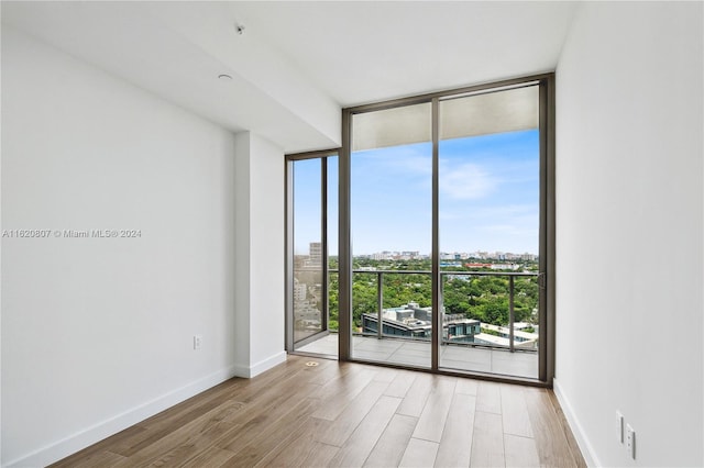 unfurnished room with expansive windows and hardwood / wood-style flooring