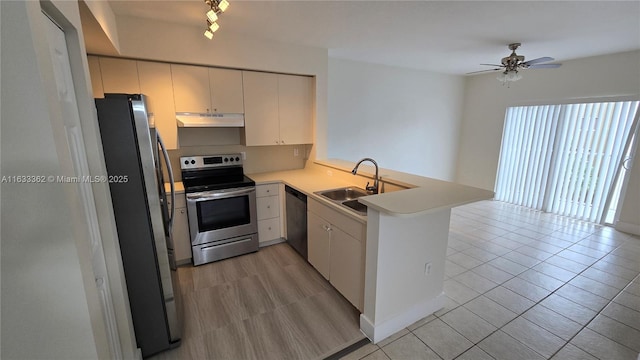 kitchen featuring ceiling fan, appliances with stainless steel finishes, a sink, a peninsula, and under cabinet range hood