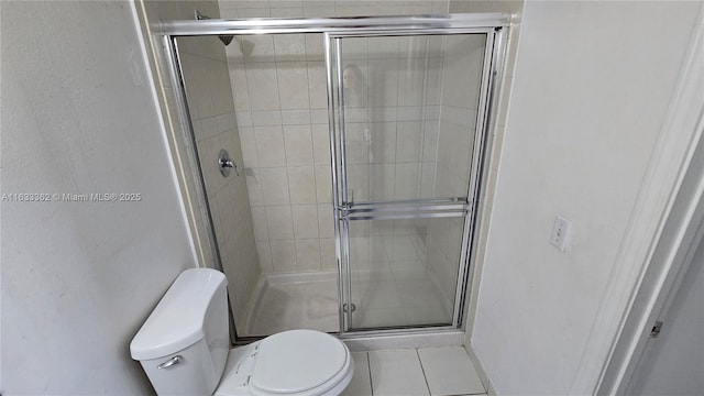 bathroom with tile patterned floors, an enclosed shower, and toilet