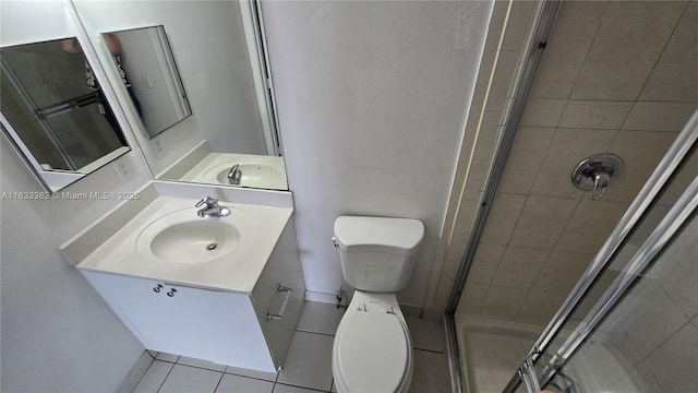 bathroom featuring tile patterned flooring, vanity, an enclosed shower, and toilet