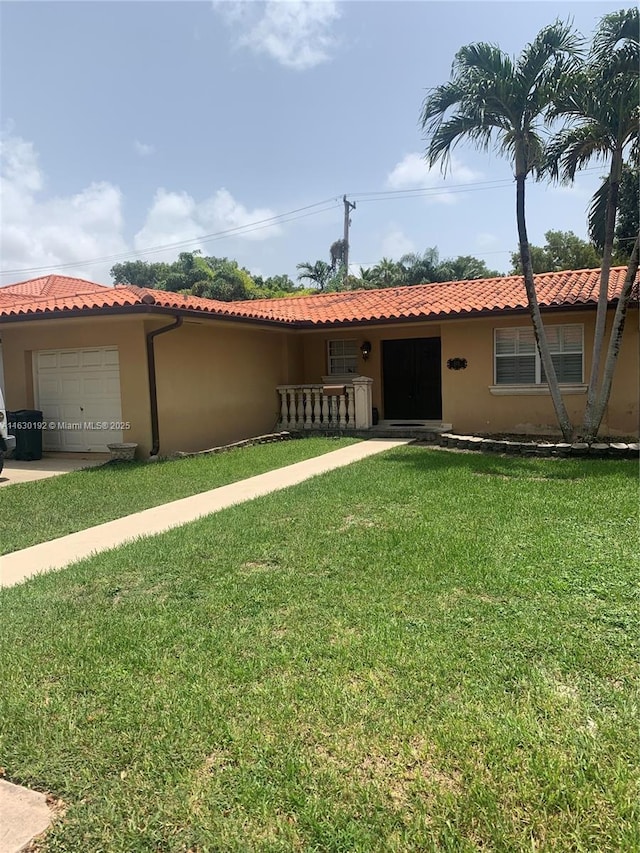 view of front of property with a front yard and a garage