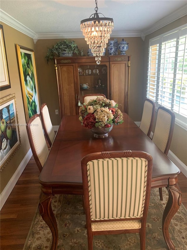 dining room with dark hardwood / wood-style floors, ornamental molding, and a chandelier