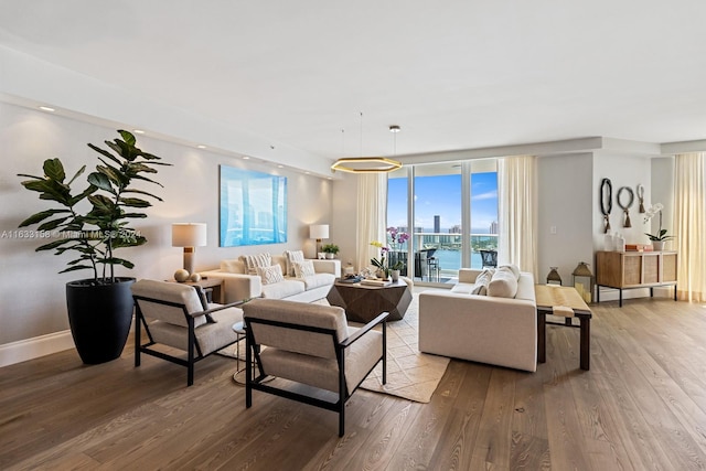 living room with light hardwood / wood-style flooring, a water view, and a healthy amount of sunlight