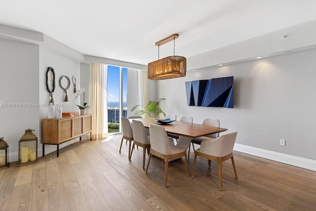 dining space featuring hardwood / wood-style flooring and a wall of windows