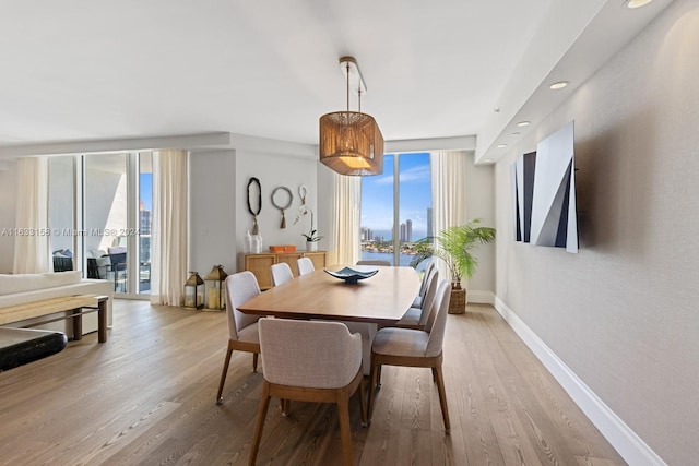 dining space with light wood-type flooring and a wall of windows