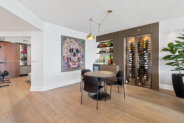 dining area featuring wooden walls and light hardwood / wood-style flooring