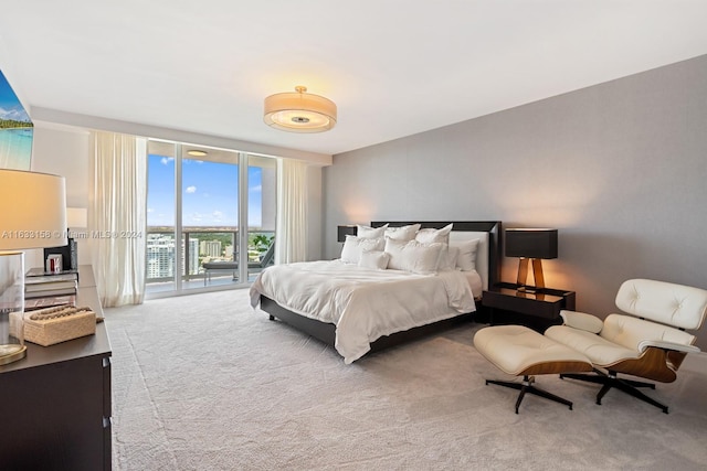 carpeted bedroom with access to exterior and a wall of windows