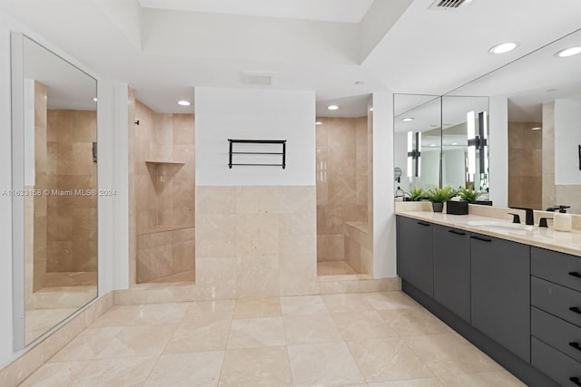 bathroom featuring tile walls, vanity, and tiled shower