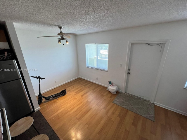 foyer entrance featuring a textured ceiling, light hardwood / wood-style flooring, and ceiling fan