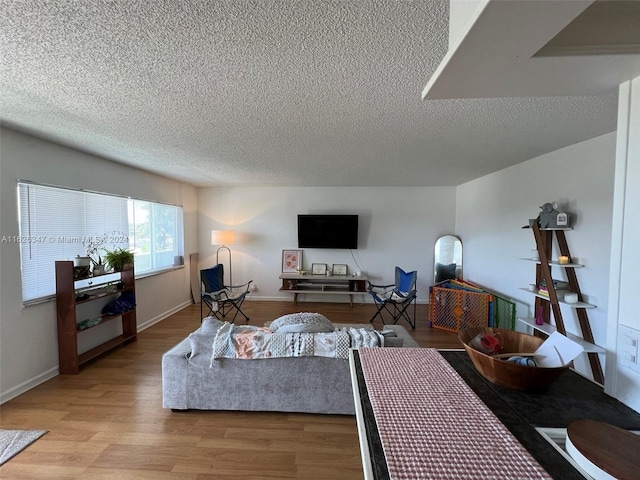 living room with a textured ceiling and light wood-type flooring