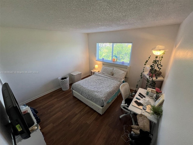 bedroom with a textured ceiling and dark wood-type flooring