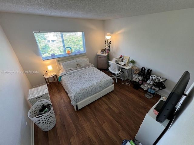 bedroom featuring wood-type flooring and a textured ceiling