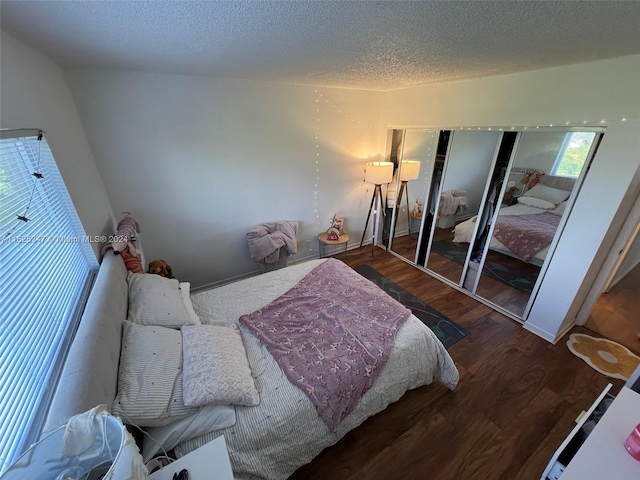 bedroom with a closet, a textured ceiling, and hardwood / wood-style flooring