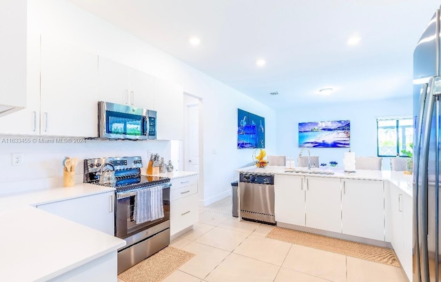 kitchen featuring stainless steel appliances, white cabinetry, sink, and light tile patterned floors