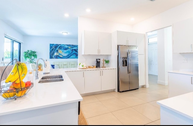 kitchen featuring sink, white cabinets, stainless steel fridge, and light tile patterned floors