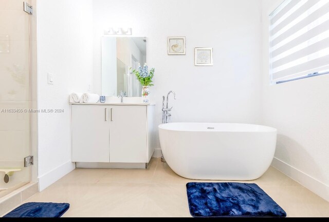 bathroom featuring tile patterned flooring, plus walk in shower, and vanity