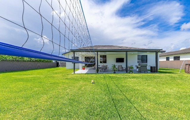 rear view of house featuring a lawn and a patio