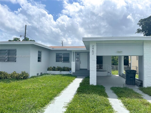 view of front of house featuring a carport and a front yard