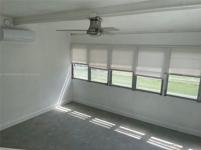 empty room featuring beam ceiling, an AC wall unit, a wealth of natural light, and ceiling fan