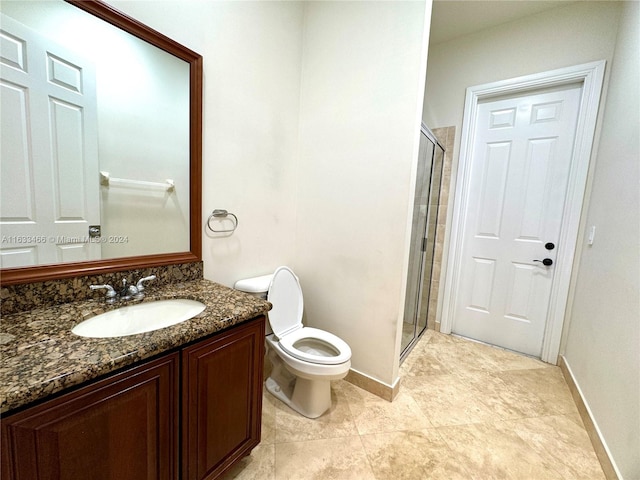 bathroom with tile patterned flooring, a shower with door, vanity, and toilet