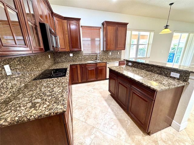 kitchen featuring sink, decorative light fixtures, backsplash, stainless steel appliances, and dark stone countertops