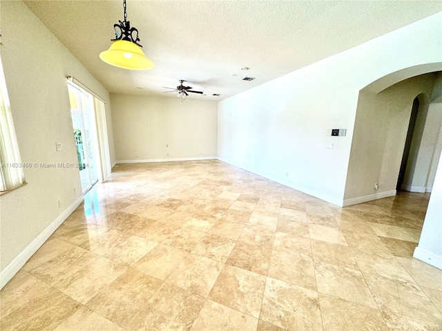 unfurnished room featuring ceiling fan and a textured ceiling