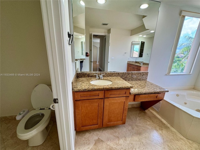 bathroom with vanity, toilet, and a tub