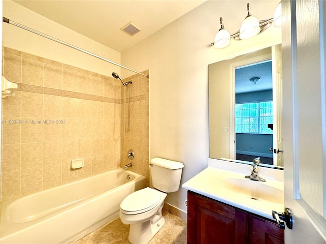 full bathroom featuring tile patterned flooring, tiled shower / bath, vanity, and toilet