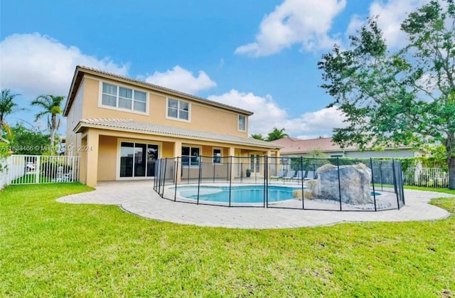 back of house featuring a patio, a fenced in pool, and a yard