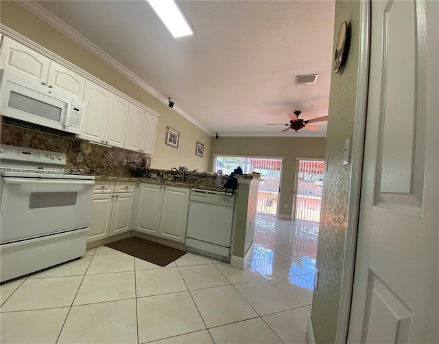 kitchen featuring white appliances, white cabinets, dark stone counters, ornamental molding, and light tile patterned flooring