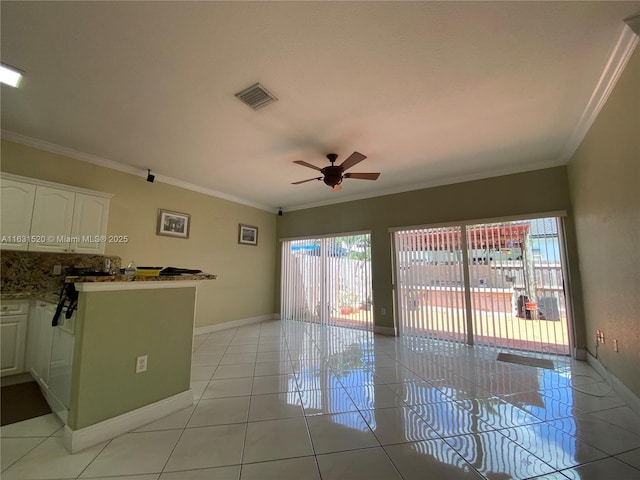 interior space featuring ceiling fan, light tile patterned flooring, and ornamental molding