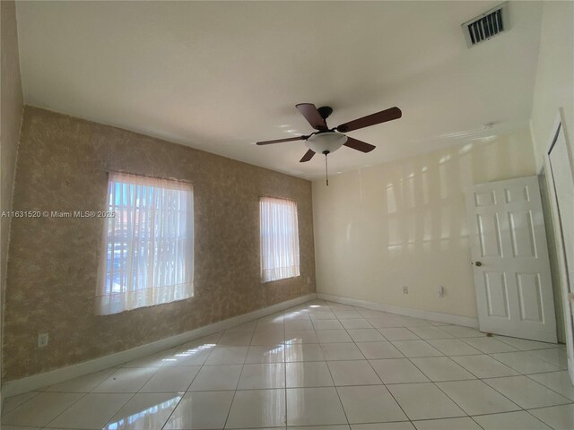 spare room with ceiling fan and light tile patterned flooring