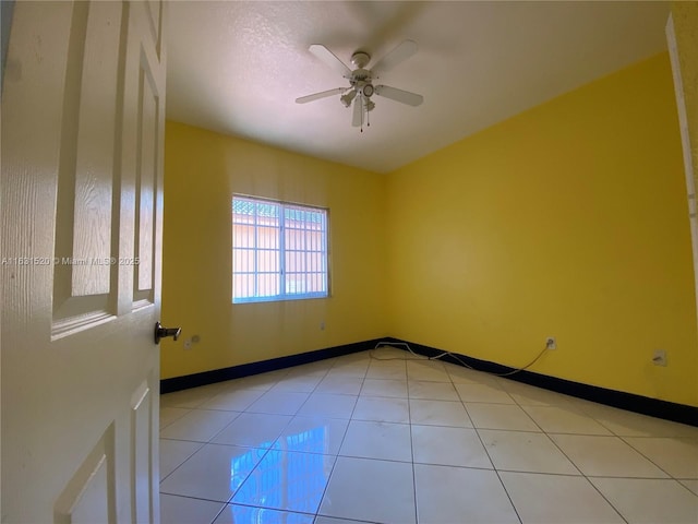 tiled spare room featuring ceiling fan