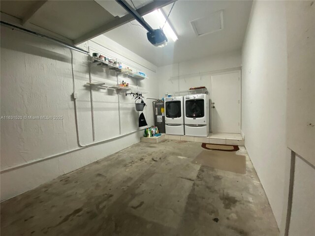 garage with washer and dryer, electric water heater, and a garage door opener