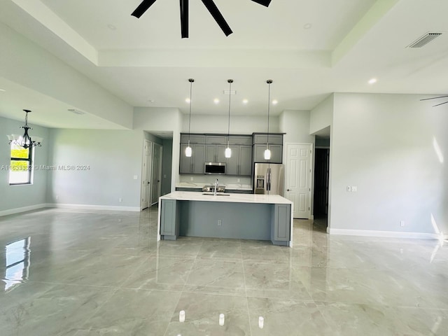 kitchen with decorative light fixtures, appliances with stainless steel finishes, gray cabinets, an island with sink, and ceiling fan