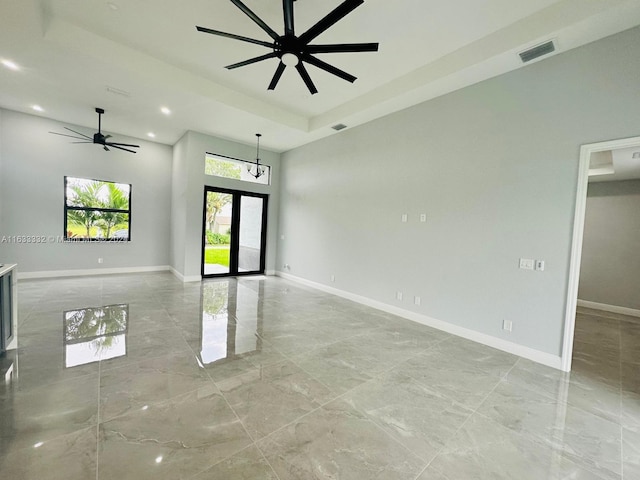 unfurnished room with a raised ceiling and ceiling fan