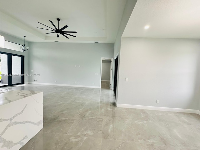 spare room with a tray ceiling and ceiling fan