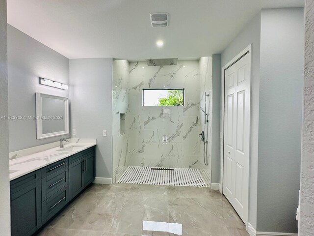 bathroom with vanity and tiled shower