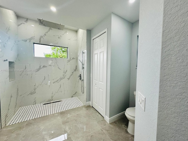 bathroom featuring toilet and a tile shower